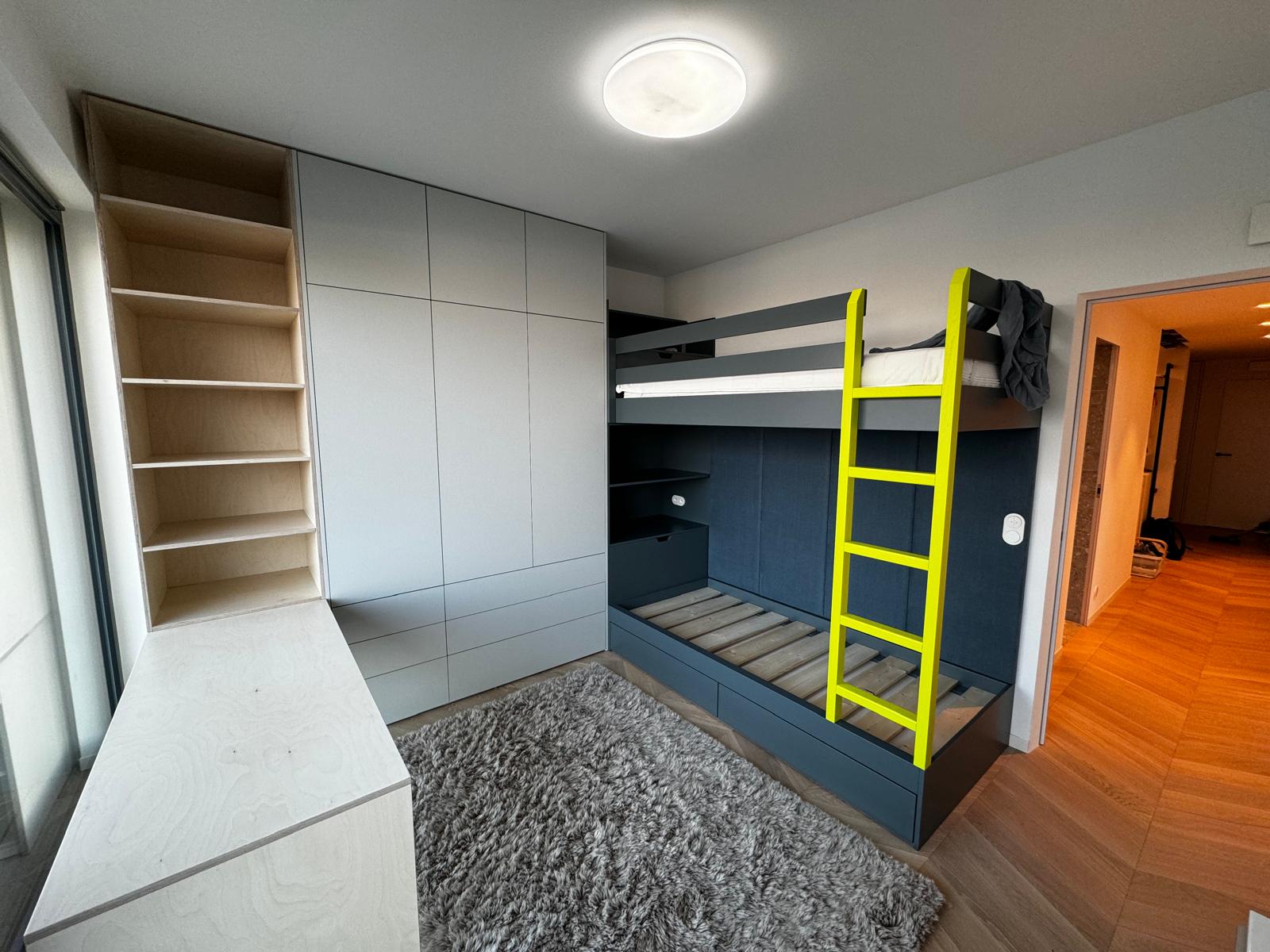 Patrová postel s výrazným žlutým žebříkem a vestavnou skříní